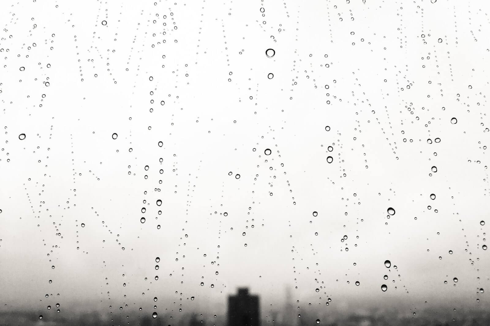 Water droplets on window with cityscape in background