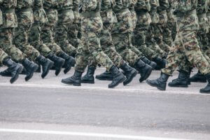 Lines of military personnel marching showing only boots and lower part of uniforms