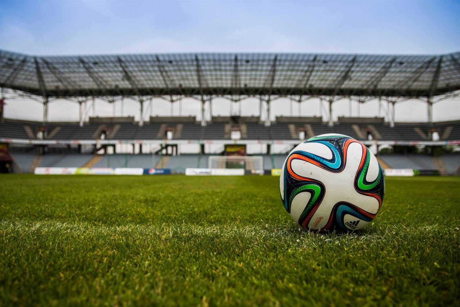 Soccer ball on soccer field while sun sets