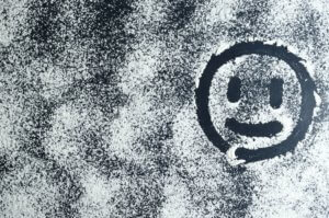 Unsure smiley face drawn by finger in snow