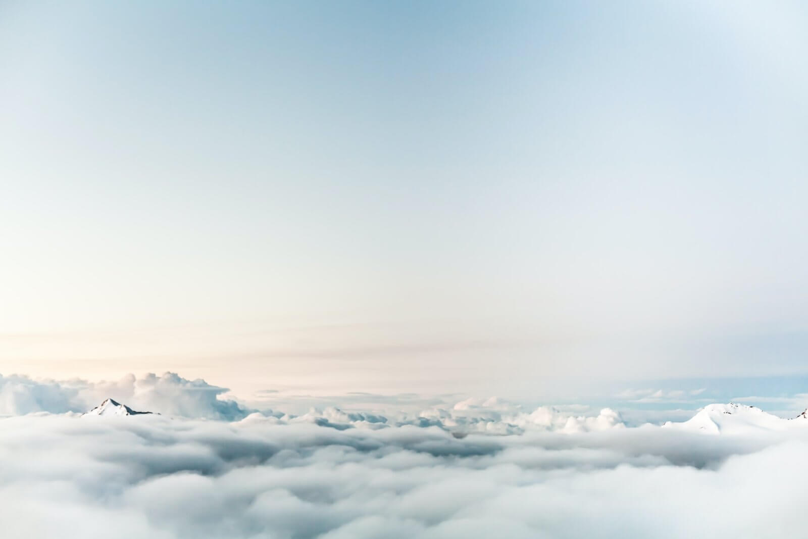 Fluffy white clouds against bright light blue sky