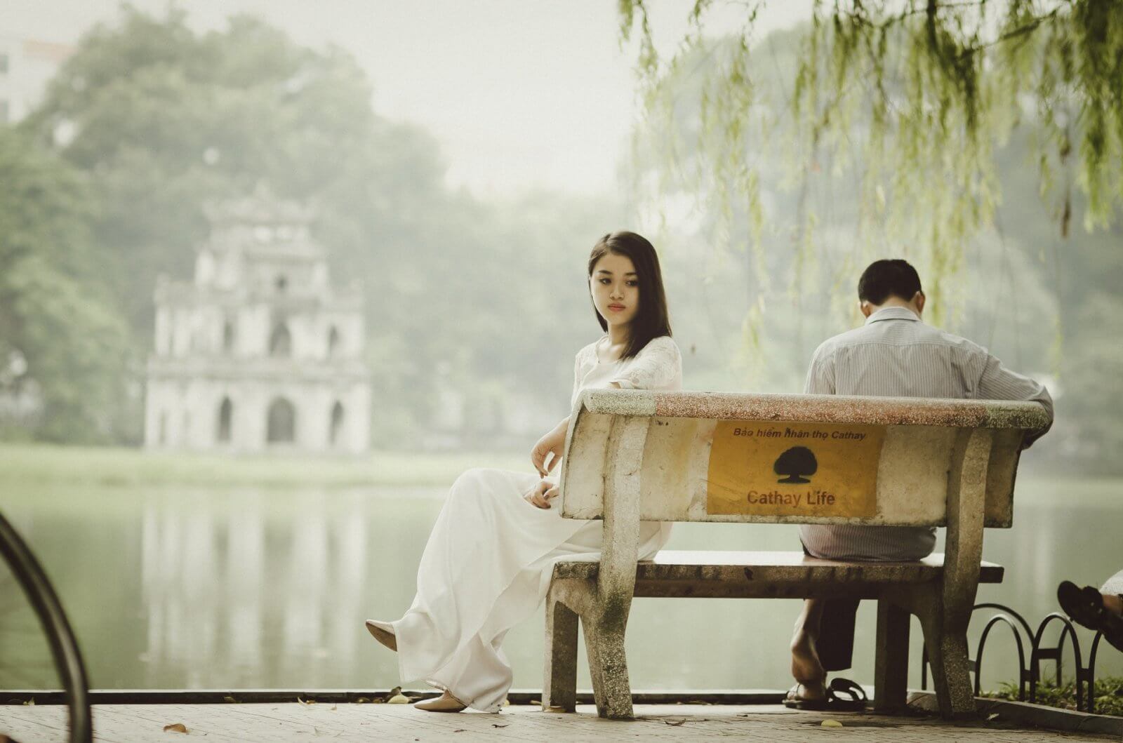 Uncertain girl on bench facing away from man