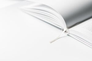 Thin open white book on white table
