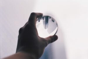 Hand holding glass ball that reflects cityscape
