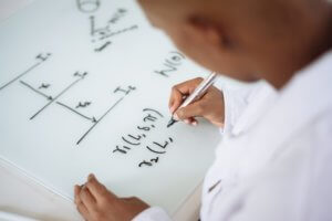 Child working on formula on markerboard